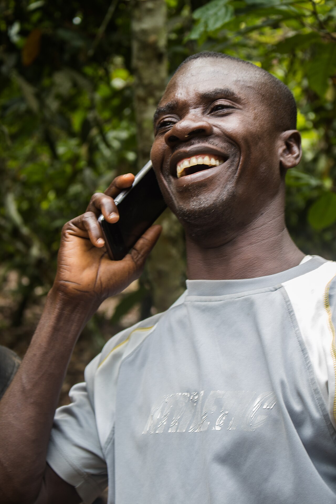 A Ghanaian cocoa farmer using a mobile phone